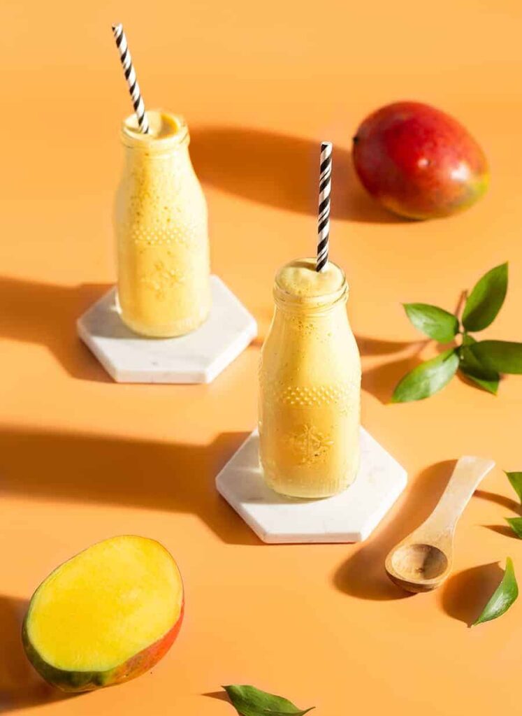 Dwie porcjeMango Lassi w butelkach ze słomką